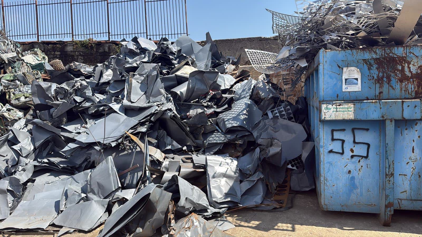 Container scarrabile IRMES accanto a cumuli di lamierino selezionato